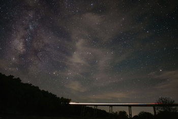 Milky way with car passing over bridge, Brazos River